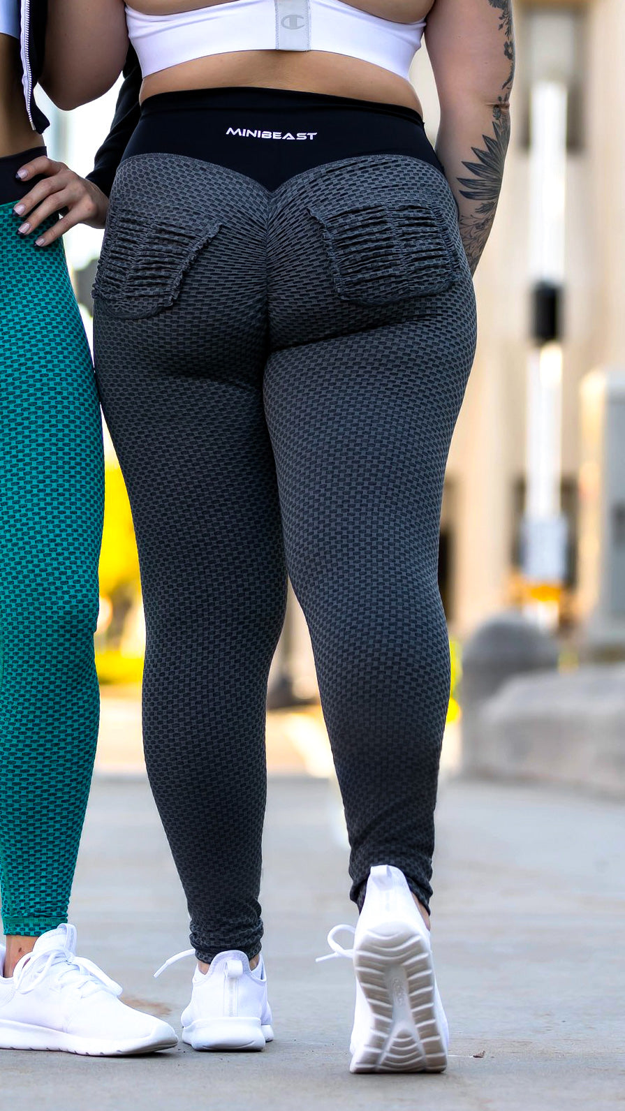The back view of a model wearing a pair of Curve X Leggings in Hex Black, complete with scrunch back pockets. 