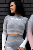 Image of a woman wearing the Pump Crop Top in grey and white from MiniBeast.